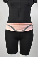 Riñonera deportiva color rosa con detalle reflectivo gris.