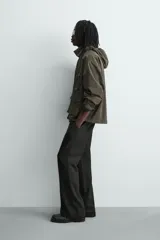 Cazadora relaxed fit de tejido con mezcla de algodón en color verde militar. Cuenta con cuello subido, manga larga con puño ajustable, múltiples bolsillos frontales de plastrón con solapa y cierre frontal con botones.