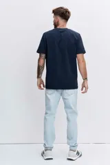 Remera de algodón color azul marino, de corte clásico y cuello redondo, con un pequeño logo bordado en el pecho.