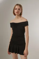 Vestido corto azul marino con escote strapless, diseño al cuerpo con frunces en el torso y falda con volados en el ruedo.