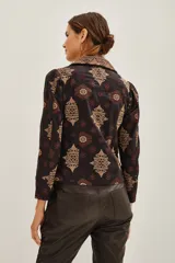 Saco de corte sastre con solapas anchas, confeccionado en algodón con estampado étnico en tonos oscuros y dorados. Presenta cierre frontal y diseño estructurado.
