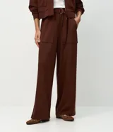 Pantalón wide leg de cintura alta en color marrón, confeccionado en modal con viscosa y elastano. Cuenta con cintura posterior elástica, cinta con hebilla para ajustar, bolsillos delanteros amplios tipo cargo y piernas rectas.