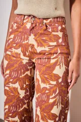 Jean wide leg de tiro medio, con estampado botánico en tonos terracota y beige, confeccionado en denim de algodón con elastano.