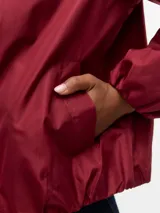 Campera bomber corta color bordó, con cuello redondo, cierre frontal de cremallera y bolsillos delanteros. Está completamente forrada.