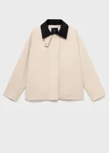 Chaqueta oversize color beige con cuello camisero de pana en contraste color negro. Presenta cierre frontal oculto con cremallera y botones, manga larga y bajo con cordón interior ajustable.