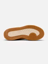 Zapatillas Sorel modelo Ona Ave Low, de diseño minimalista en color crema con suela de plataforma dentada en tono caramelo. Presenta cierre de cordones con ojales metálicos dorados y logo de la marca grabado en el lateral.