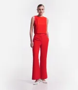 Pantalón flare de sastrería color rojo, con cintura alta, trabillas y cierre cruzado con botones.