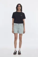 Short de denim tiro alto con diseño de rayas verticales celestes, blancas y negras, fit relaxed y bolsillos funcionales.