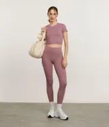 Remera cropped deportiva Get Over, color malva, de cuello redondo, mangas cortas y calce ajustado. Confeccionada en mezcla de poliéster y elastano de tacto suave.