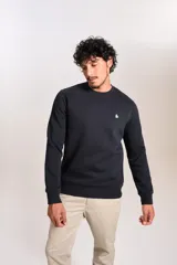 Buzo de cuello redondo en color azul marino, con ajuste elástico en puños y cintura. Presenta un pequeño logo bordado de un pingüino en el lado izquierdo del pecho.