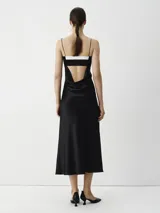 Vestido largo midi negro con breteles finos y escote recto con detalle blanco.