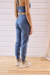 Pantalón tipo babucha de tiro alto, con cintura elástica ancha, bolsillos laterales y puños ajustados en los tobillos.