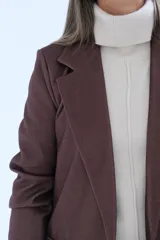 Blazer de corte sastrero en color marrón chocolate, con solapas clásicas, bolsillos delanteros con solapa y costuras a la vista en tono contrastante.