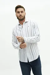 Camisa de manga larga de lino y algodón, color blanco con rayas verticales en tonos gris y beige. Presenta un corte semi slim y un pequeño logo bordado en el pecho.