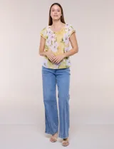 Blusa de gasa semitransparente color azul marino con estampado floral en tonos celestes y lilas, cuello redondo elastizado con lazo central y mangas cortas con doble volado.