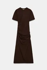 Vestido largo color marrón oscuro, con cuello redondo, manga corta y detalle de drapeado fruncido en el lateral izquierdo, terminando en línea evasé.