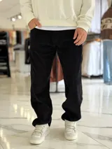 Pantalón baggy de pana color negro, con diseño de corte recto y holgado.