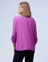 Blusa texturada color violeta, marca Ruby Rd. Tiene cuello a la base con escote en V y mangas largas con largo regulable.