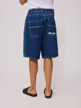 Bermuda de jean de mezclilla negra con efecto lavado, corte recto y costuras en contraste de hilo blanco. Presenta un parche bordado con el logo "Rusty" en color celeste en el bolsillo trasero derecho.