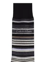 Pack de tres pares de medias largas Calvin Klein, incluye dos pares negros lisos con logo CK y un par a rayas horizontales en tonos grises con logo Calvin Klein.