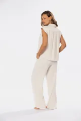 Pantalón confeccionado en mezcla de lino y viscosa, color beige, de corte recto. Cuenta con media cintura elastizada, bolsillos laterales y detalles de pinzas en el frente.