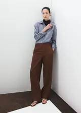 Camisa de corte recto con diseño de rayas, cuello camisero, manga larga con puños abotonados, bolsillo de parche en el pecho y cierre delantero con botones.
