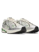 Championes de estilo urbano con diseño chunky, base de malla color crema y superposiciones metálicas plateadas. Presenta detalles en verde y negro, con suela robusta de goma en tono crema y acentos verdes.