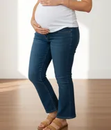 Jean maternal azul lavado, elastizado, de corte flare, con faja de algodón de altura media con elástico ajustable y detalles de tachas cromadas.