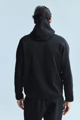 Campera deportiva negra con capucha, cierre frontal y bolsillos laterales con cierre. Confeccionada en tejido funcional efecto neopreno con tecnología DryMove™ para absorber el sudor.