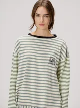 Remera manga larga de corte oversize y cuello redondo, con diseño a rayas horizontales en tonos claros y verde militar, y detalle de bordado frontal.