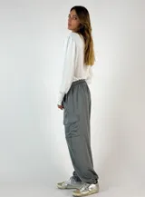 Pantalón cargo color marrón de seda con bolsillos laterales con solapa, cintura elastizada con cordón ajustable y corte holgado.