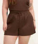 Short color beige de sarga de algodón, con cintura elástica, lazo ajustable y bolsillos laterales. Corte holgado.