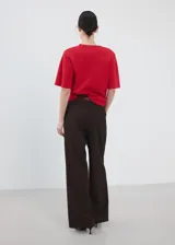 Chaleco rojo de punto fino, de diseño recto, cuello redondo y manga corta.