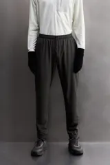 Pantalón de jogging negro confeccionado en tejido técnico ligero y elástico, corte slim fit, con cintura elástica ajustable con cordón, bolsillos laterales y trasero con cierre de cremallera, bandas reflectantes en las piernas y bajos ajustables con cremallera.