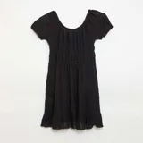 Vestido corto de manga corta color negro con escote cuadrado, detalle de lazo en el pecho y diseño fruncido con volado en el ruedo.