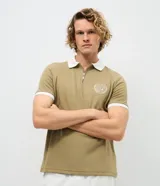 Polo de manga corta color azul marino con cuello y bordes de mangas en color blanco. Presenta cierre frontal parcial y escudo bordado en el pecho.