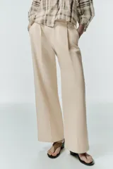 Pantalón de tiro alto con pinzas delanteras, bolsillos frontales y pernera recta. Cuenta con cierre frontal de cremallera, botón interior y gancho.