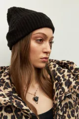 Gorro de lana tejido en ochos con vuelta acanalada y parche frontal con logo de la marca Daniel Cassin.