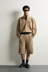 Bermuda estilo jogger de ajuste relajado, color beige, con cintura elástica ajustable mediante cordón y bolsillos delanteros.
