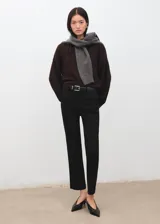 Pantalón negro de vestir, de corte recto y tiro medio, con trabillas para cinturón y bolsillos.