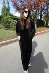 Conjunto de dos piezas confeccionado en tejido plush aterciopelado color negro. Incluye un buzo de corte cropped con cuello redondo y mangas largas, y un pantalón estilo cargo de silueta holgada con bolsillos laterales funcionales y puños ajustables en los tobillos.