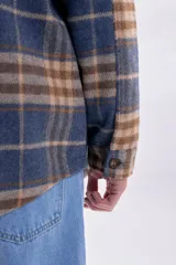 Sobrecamisa de franela a cuadros en tonos azul marino y marrón, con cierre frontal de botones, cuello camisero y bolsillos frontales con solapa.