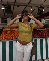 Collar corto de estilo artesanal, compuesto por una variedad de piedras naturales en tonos tierra, verdes, rojos y amarillos, intercaladas con pequeñas perlas de río. Presenta dijes de bronce macizo con formas orgánicas, incluyendo una figura de pez y un dije circular central, unidos por un cierre de barra y argolla.