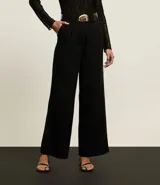 Pantalón pantalona de cintura alta, confeccionado en viscolino, con trabillas en la cintura y bolsillos falsos atrás. Incluye cinturón de material sintético con hebilla metalizada con efecto martillado.