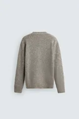 Jersey de punto perlado con ajuste relajado, cuello redondo y manga larga, con acabados en rib en puños y cintura.