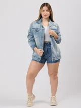 Campera de jean celeste con detalles de roturas, corte oversize, cuello clásico, cierre con botones metálicos, bolsillos frontales con solapa y puños abotonados.