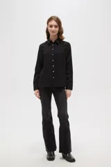 Camisa de poliéster color crema con estampado de pequeños puntos negros, cuello clásico, cierre frontal con botones y mangas largas con puños abotonados.