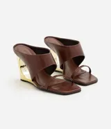 Sandalias tipo mule de color marrón, con tiras anchas en el empeine, tira fina separadora de dedos, puntera cuadrada y taco chino calado con acabado dorado metalizado.