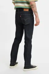 Jean de corte skinny, color azul oscuro, con tiro medio y cierre frontal con botón y cremallera. Presenta un diseño de cinco bolsillos clásico.