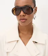 Trench coat Cortelle de gabardina de viscosa color beige, con diseño largo, mangas largas, cuello alto con solapas y cierre cruzado con botones carey. Incluye tira para anudar en la cintura y bolsillos laterales.